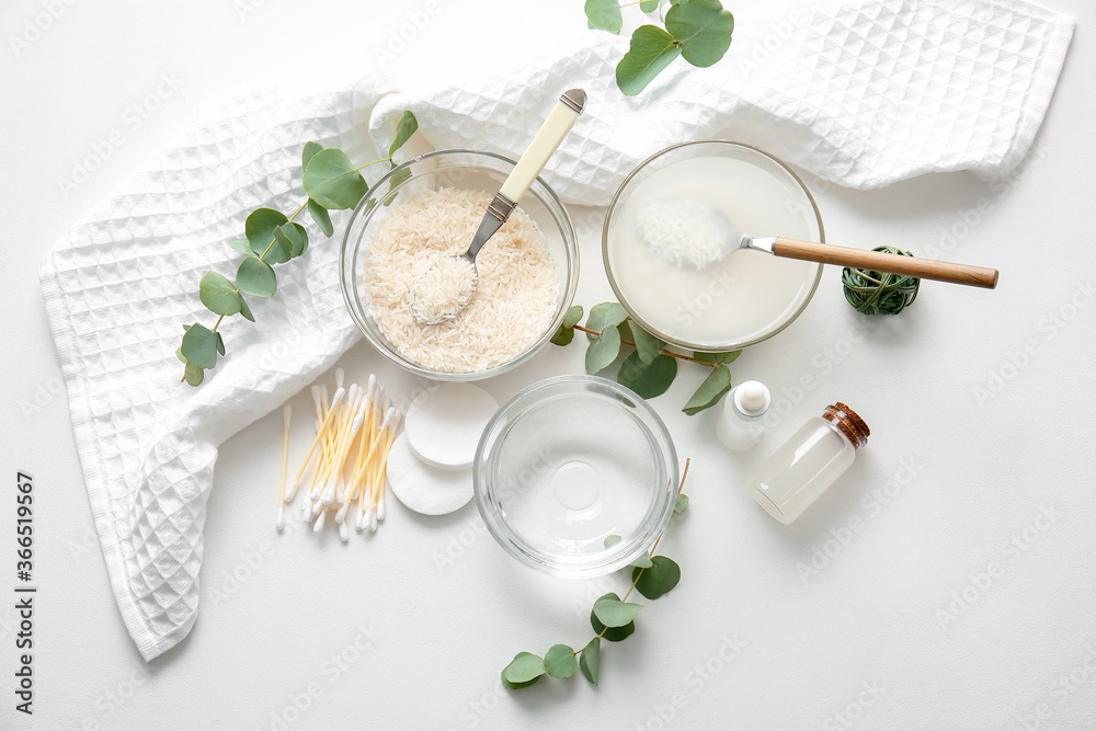 Healthy rice water with cosmetic supplies on white background