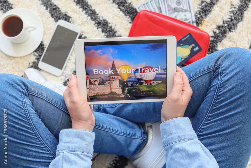 Woman with tablet computer booking tickets online at home