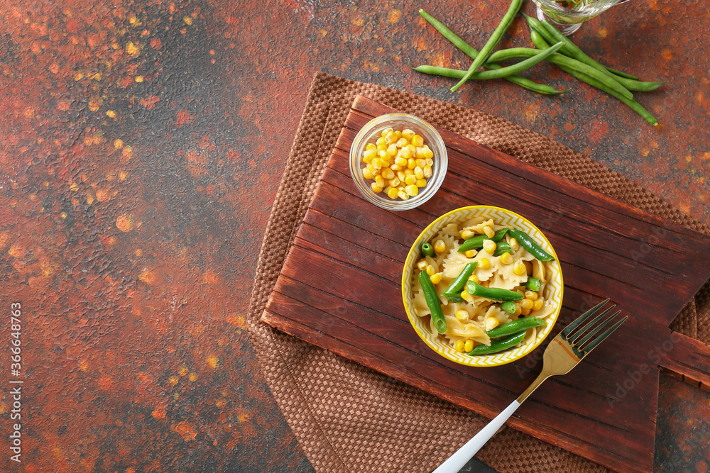 Bowl with tasty pasta salad on color background