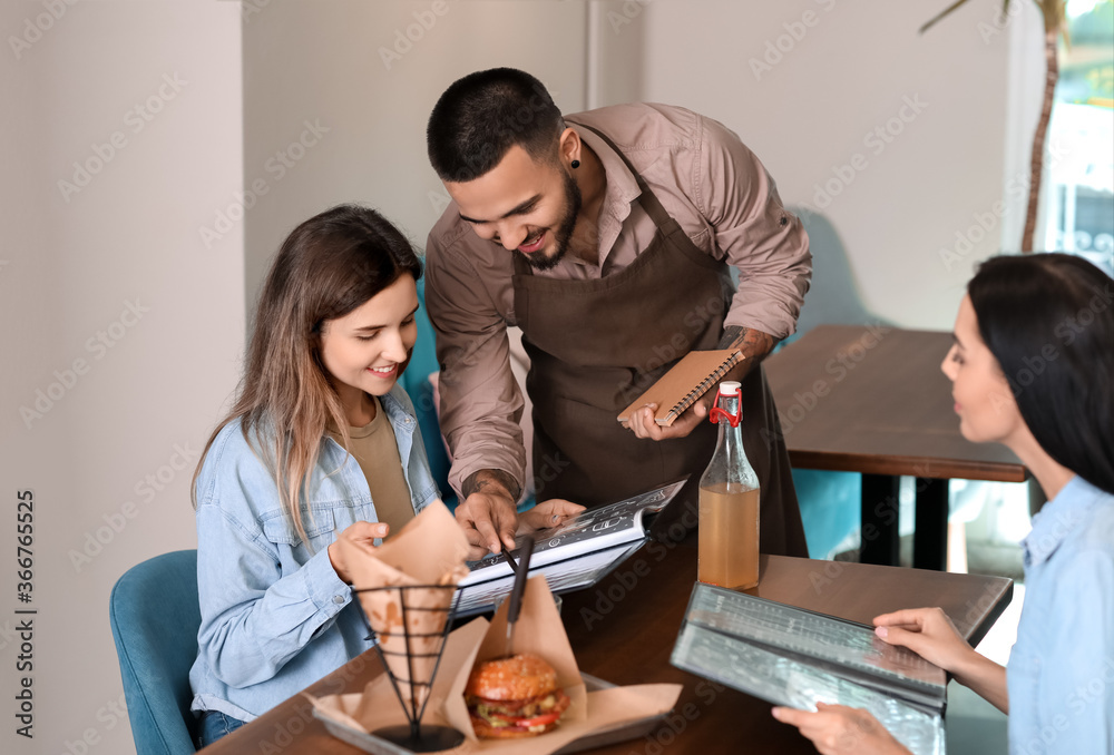 Waiter serving clients in restaurant