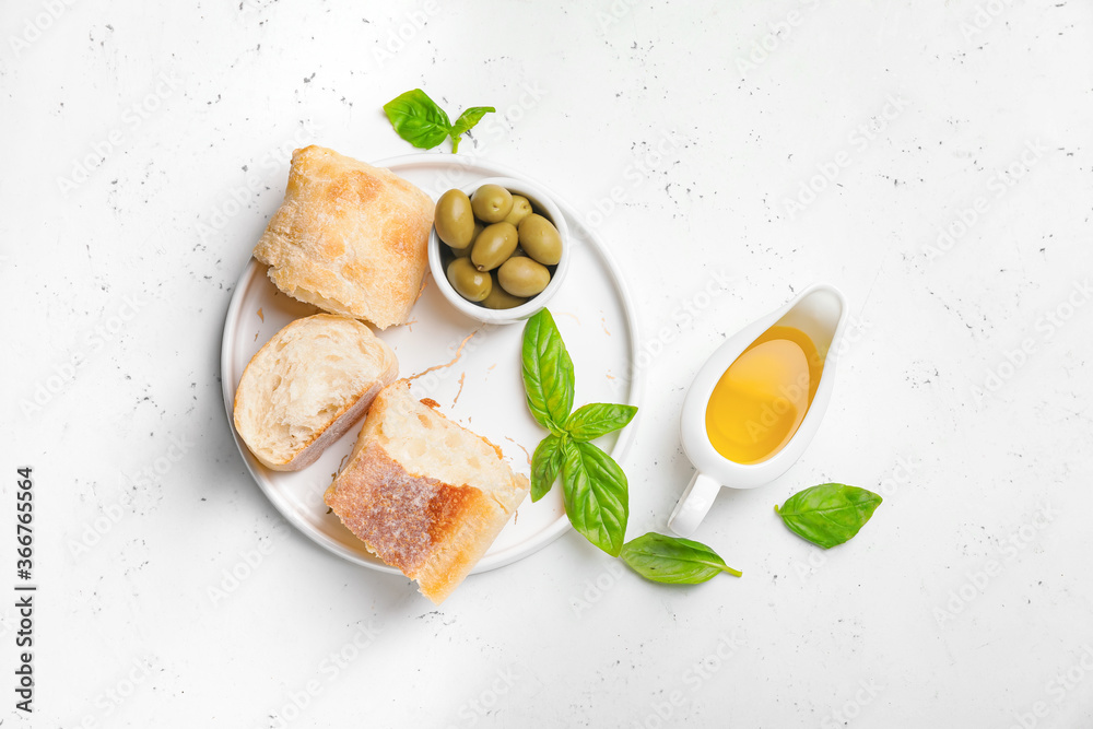 Gravy boat of tasty olive oil and bread on white background