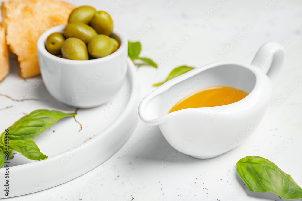 Gravy boat of tasty olive oil on white background