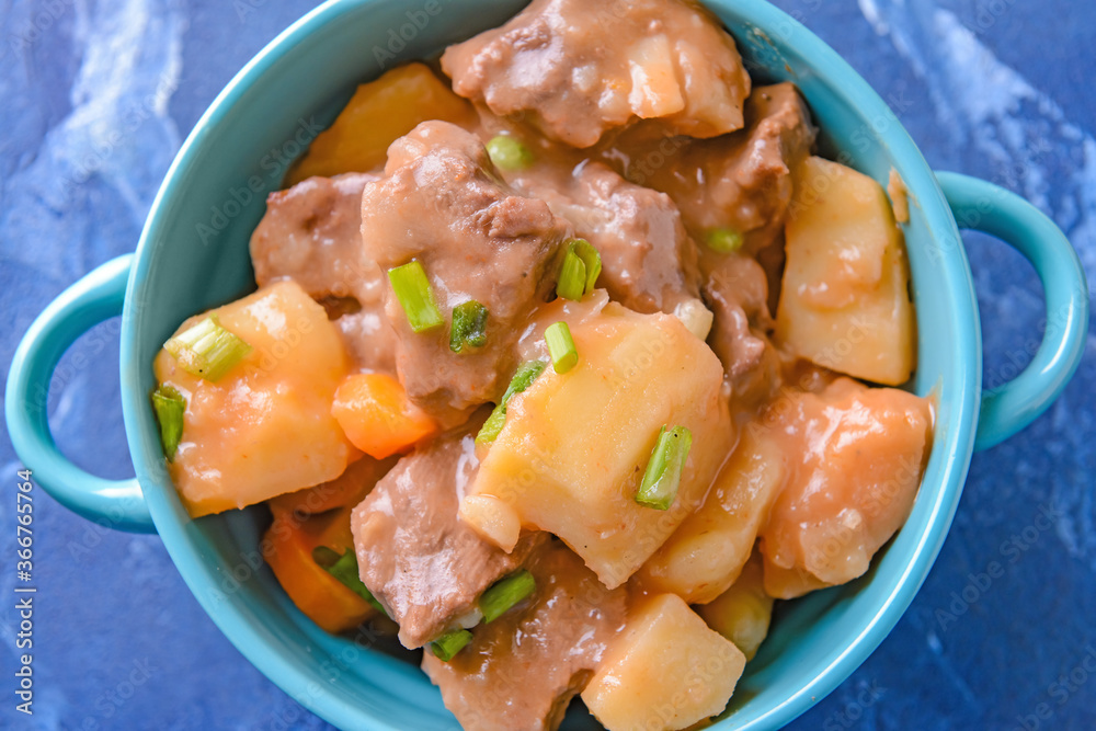 Pot with tasty beef stew on table