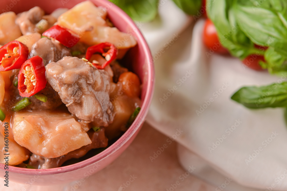 Bowl with tasty beef stew on table, closeup