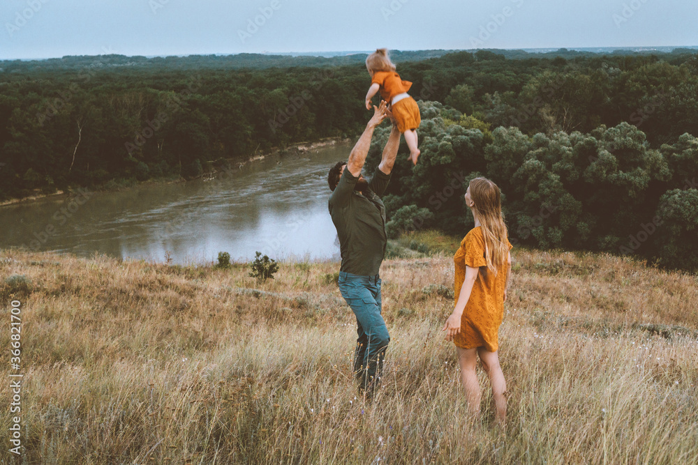 Family father and mother with child playing outdoor parents with baby having fun active healthy life