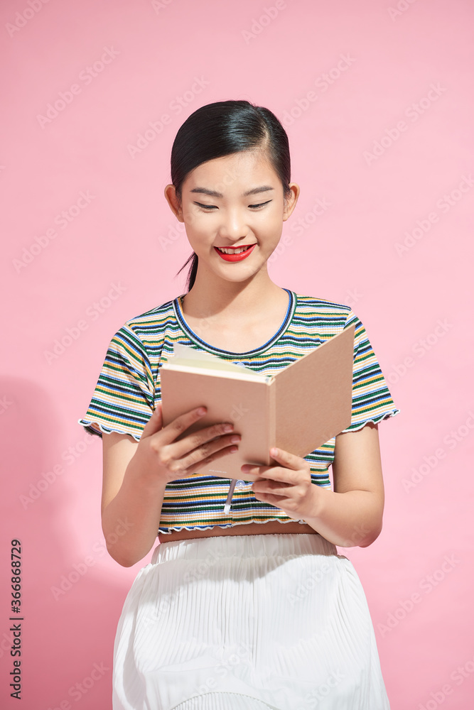 Portrait of attractive asian student ( woman ) standing holding reading a book with copy space over 