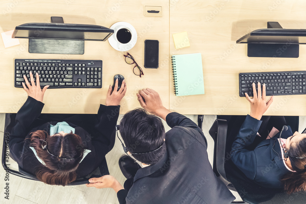 Business people wearing headset from top view in office working with computer to support remote cust