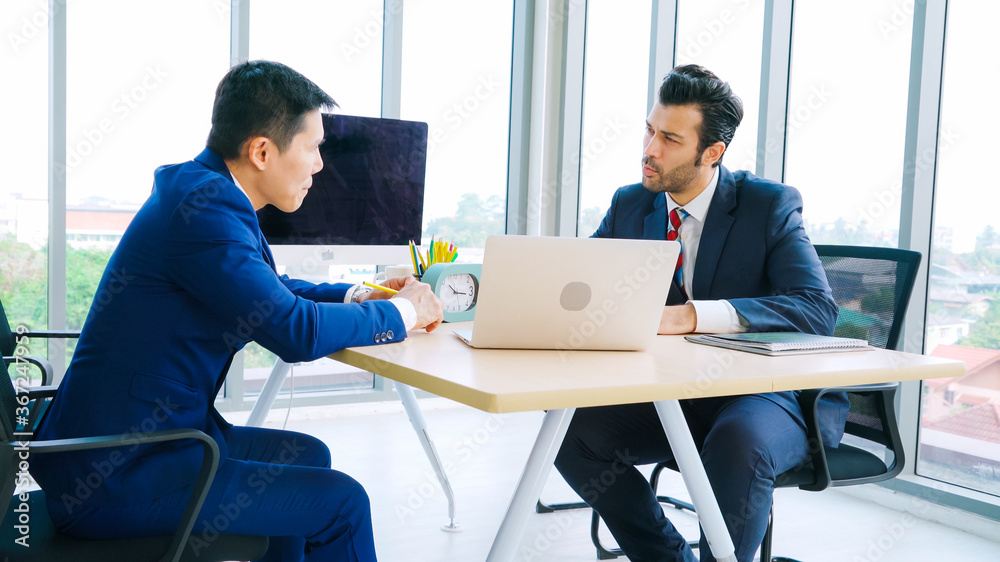 Two business people talk project strategy at office meeting room. Businessman discuss project planni