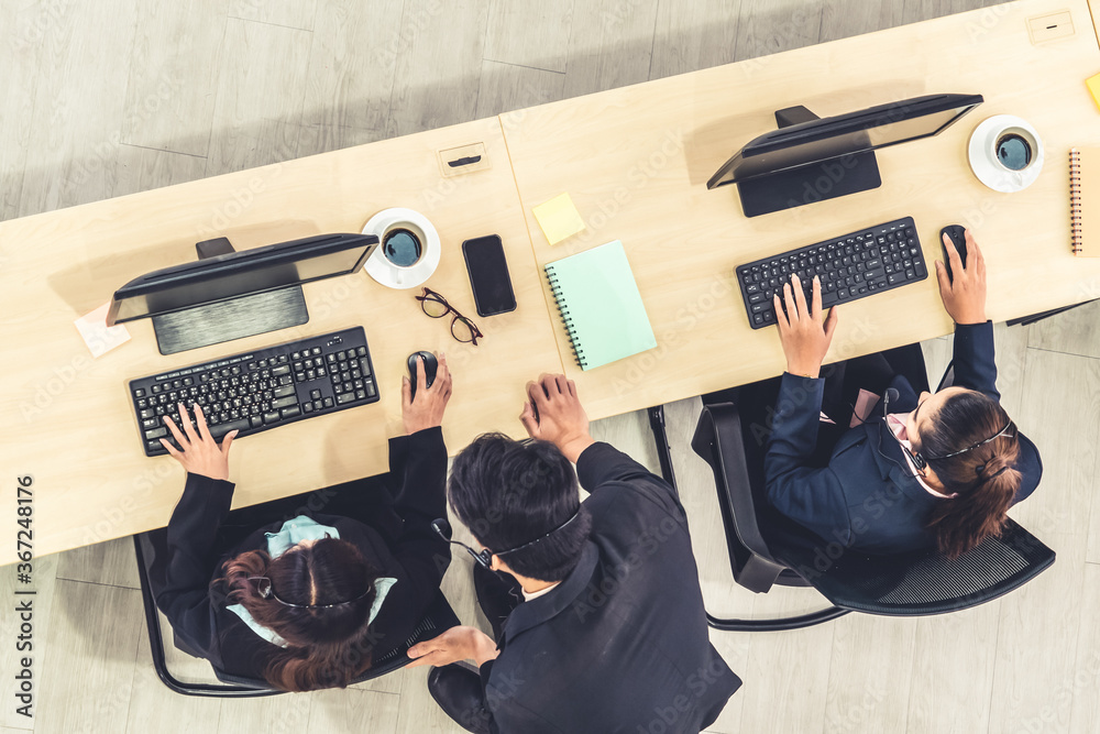 Business people wearing headset from top view in office working with computer to support remote cust