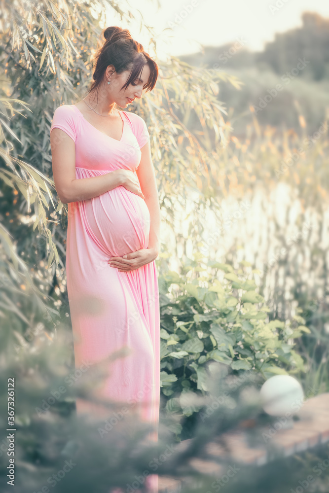 Pregnant happy Woman touching her belly. Full length Pregnant beauty young mother outdoor portrait, 