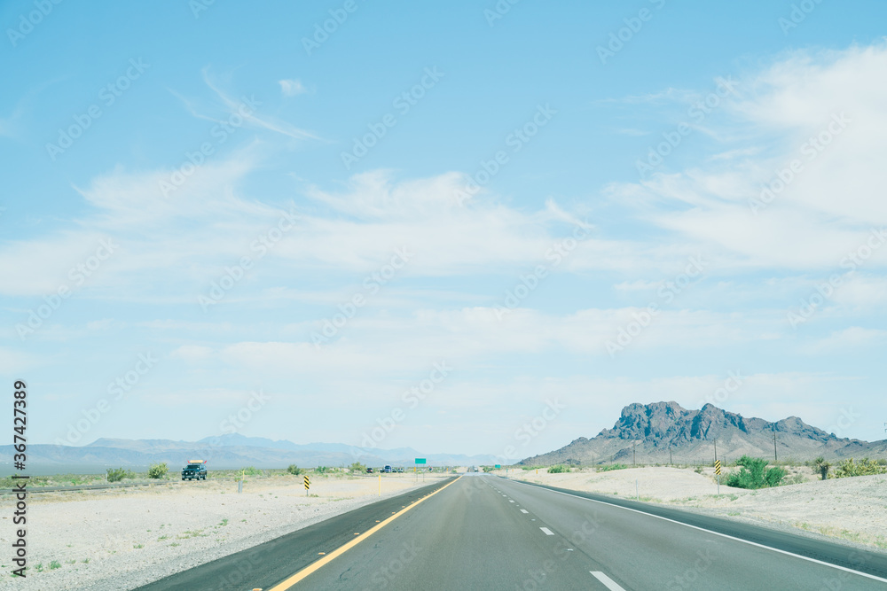 笔直的道路沿着两侧贫瘠的土地延伸。高速公路的景色一直延伸