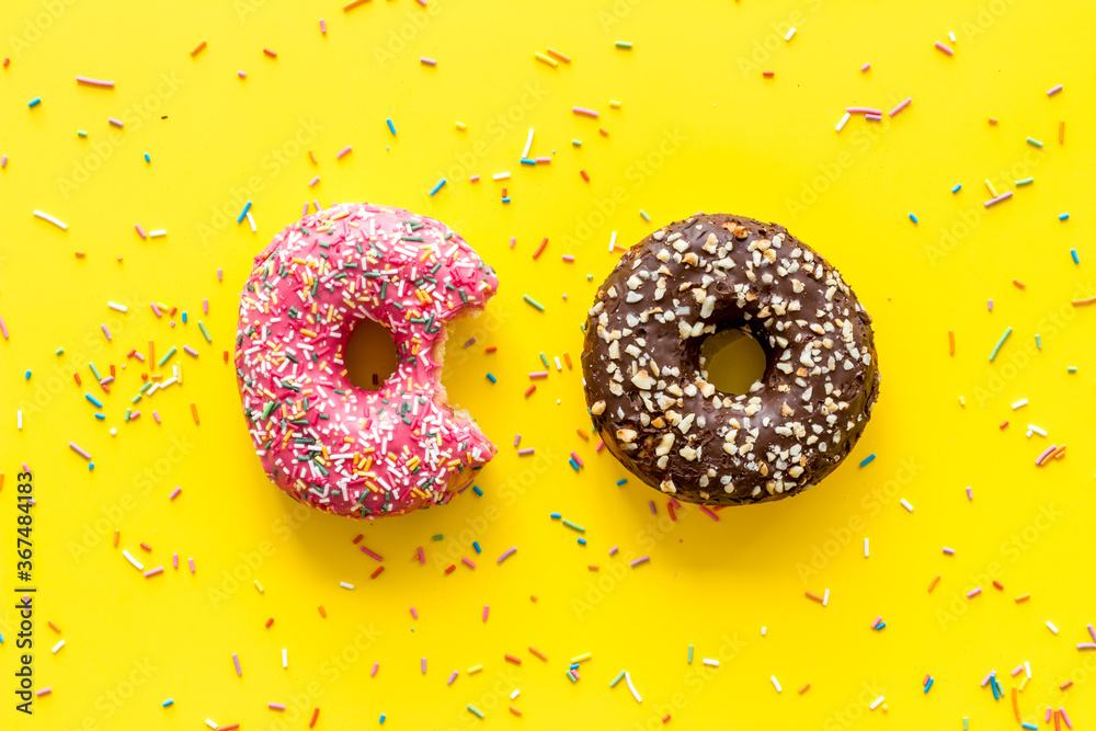 Colorful donuts pink and chocolate icing. Flat lay of bakery, above view