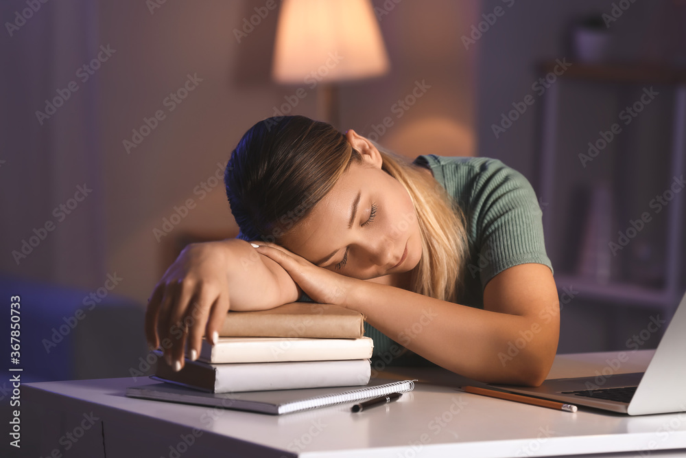 Student sleeping at table late in evening