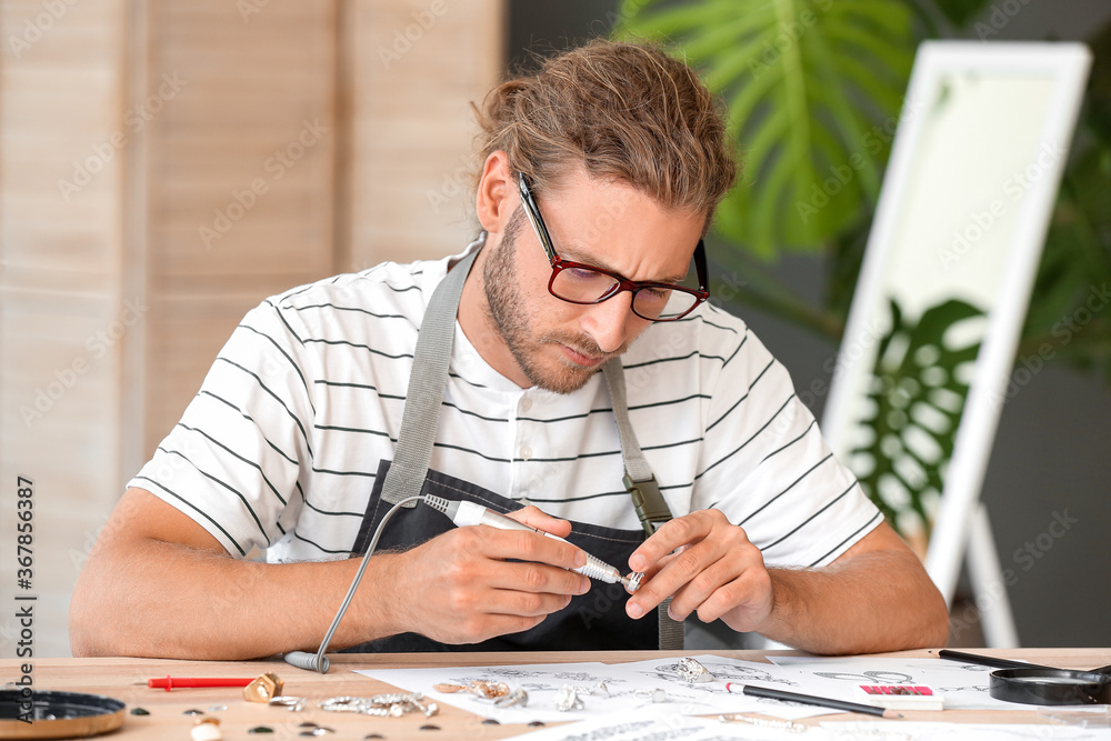 Male jewelry designer working in office