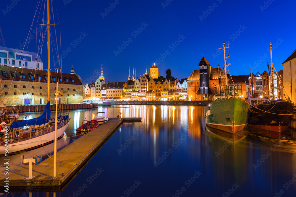 Historical port crane in Gdańsk over the Motlawa river at night, Poland.