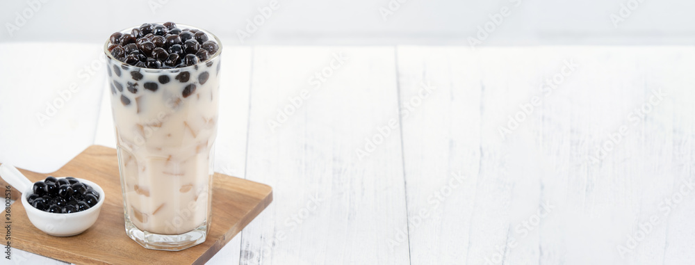 Bubble milk tea with tapioca pearl topping, famous Taiwanese drink on white wooden table background 