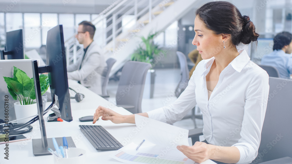 Beautiful Businesswoman, Economist, Stock Broker Uses Desktop Computer, Typing on a Keyboard, Lookin