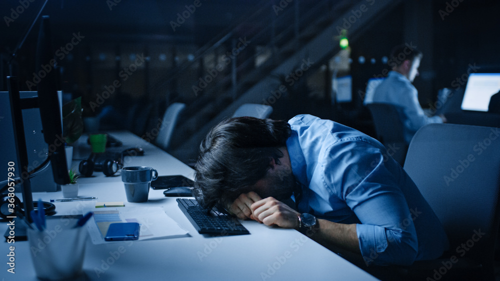 In the Office at Night Overworked Tired Office Worker Uses Desktop Computer but Falls Asleep Fast. T