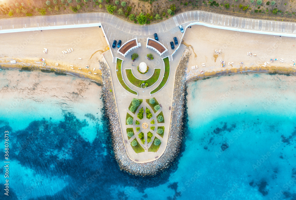 Aerial view of beautiful sandy beach, clear blue sea, promenade, swimming people in clear water, gre