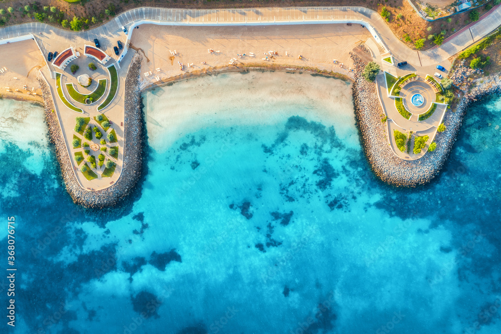 Aerial view of beautiful sandy beach, clear blue sea, promenade, swimming people in clear water, gre