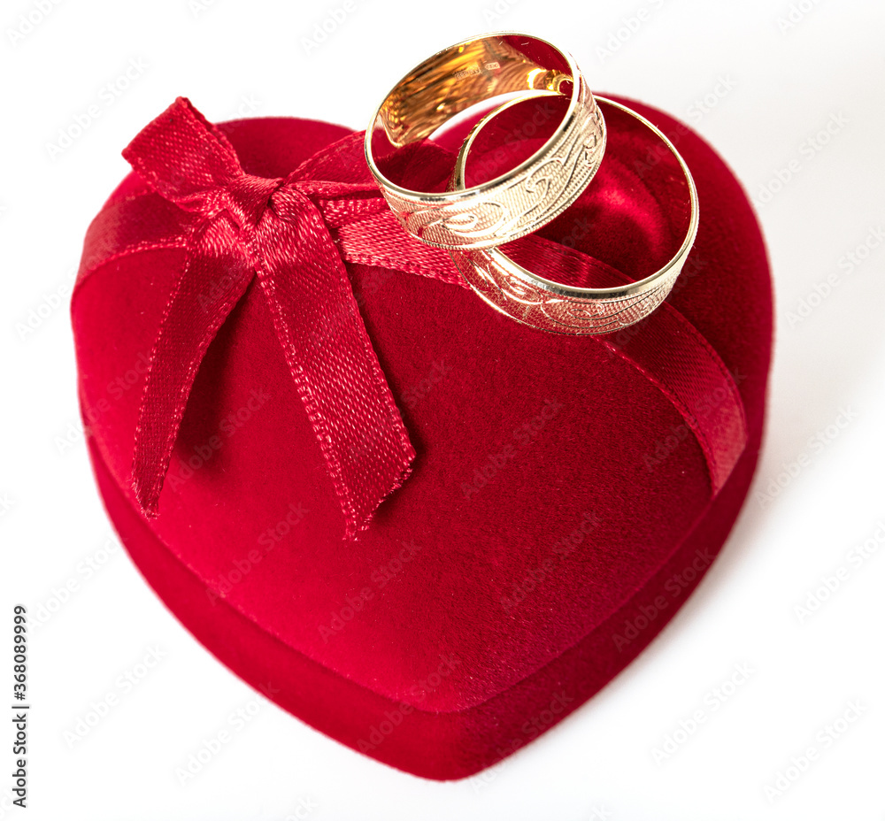 Two wedding rings red box shape of a heart.