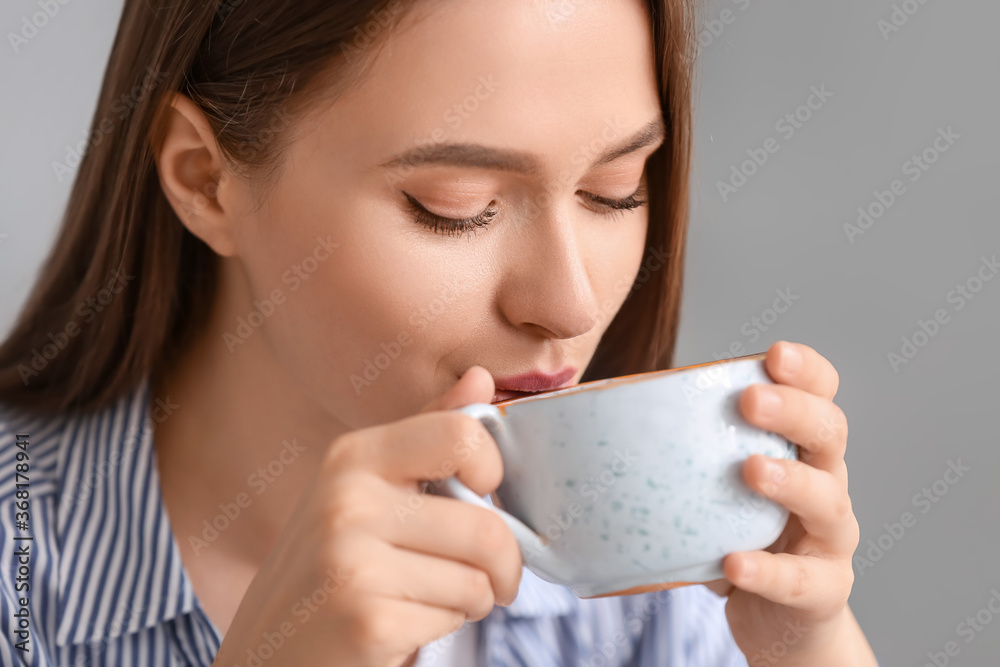 Beautiful young woman drinking tea at home