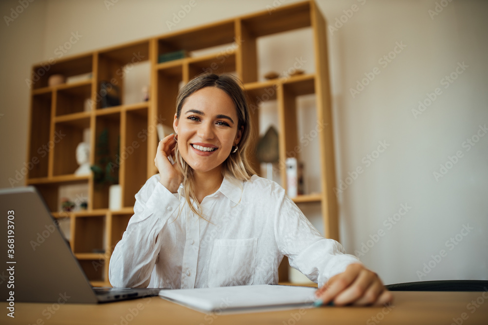 Portrait of a smiling young businesswoman working at home office.