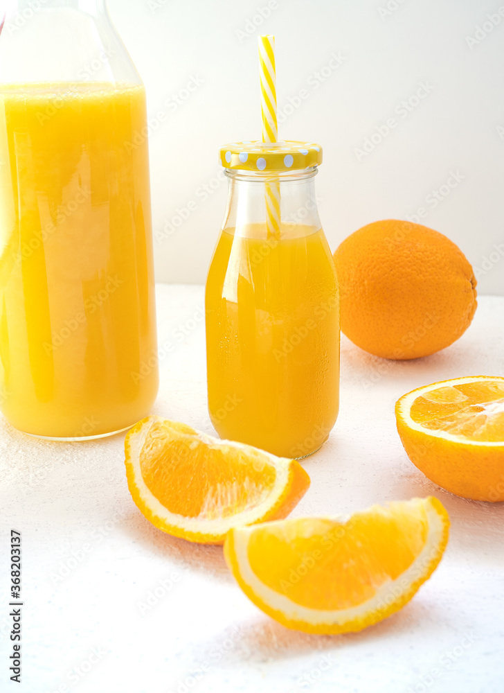 Sweet orange juice in a glass bottle with a cap and a cocktail tube stands on a white background. Ne