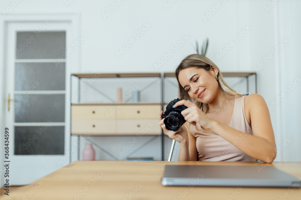 Portrait of a females journalist looking at pictures on camera.