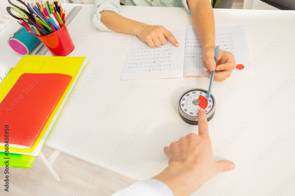 Teacher womans hand point to the lesson timer during development class exercise