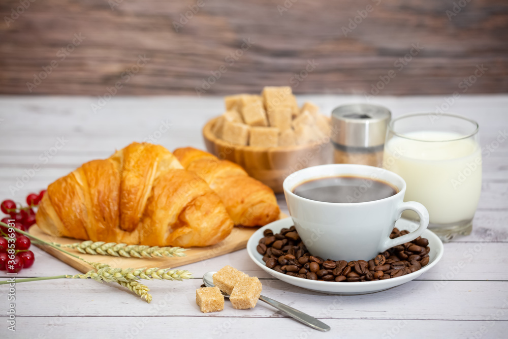 Breakfast in the morning with black coffee cup with bread with Croissant and fruit on the wooden tab