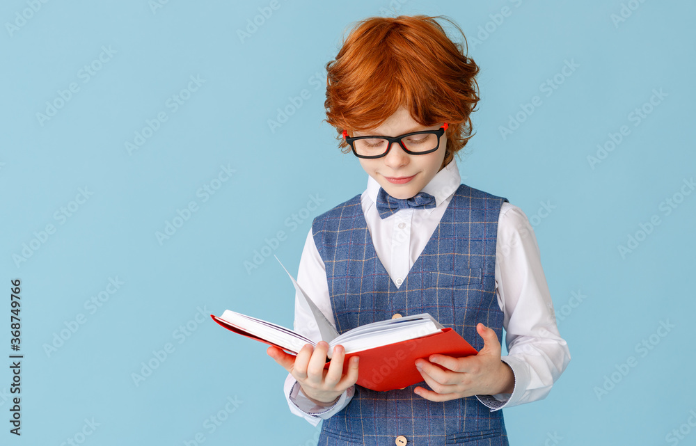 Cheerful boy with textbook during lesson.