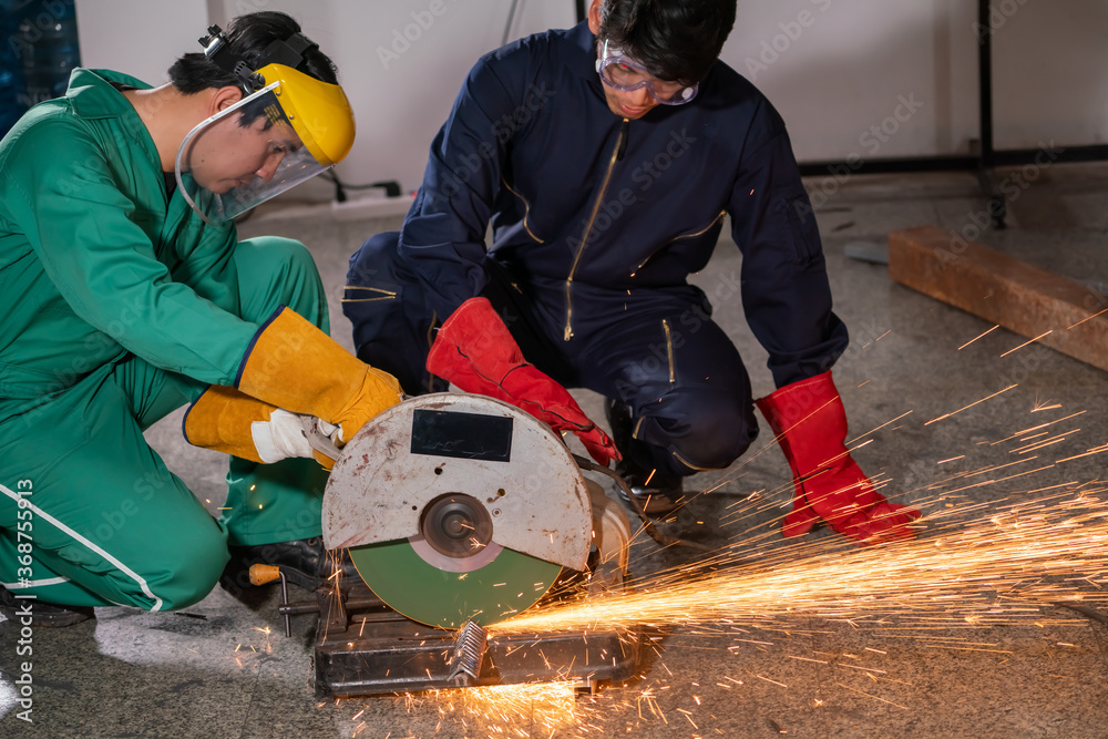 Professional mechanic man is cutting steel metal with rotating carbon blade cutter. Steel industry a