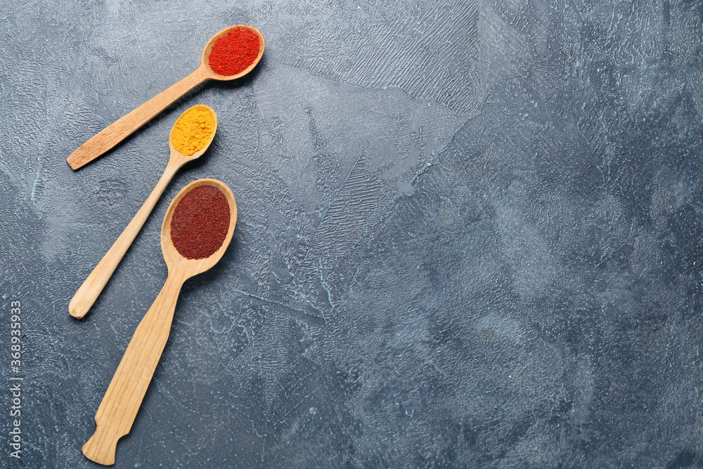 Spoons with different spices on table