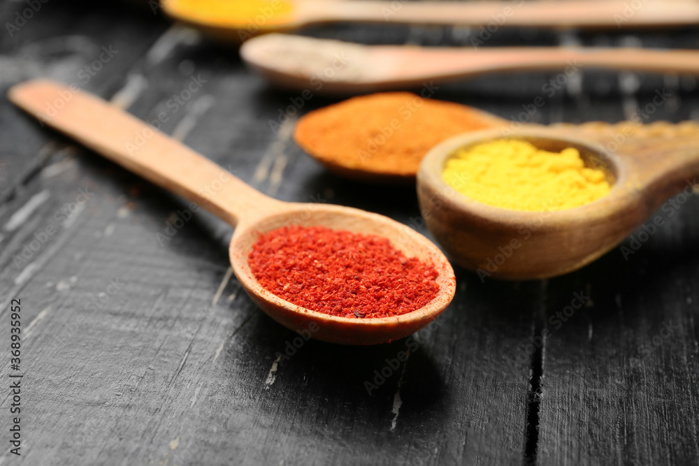 Many spoons with different spices on table