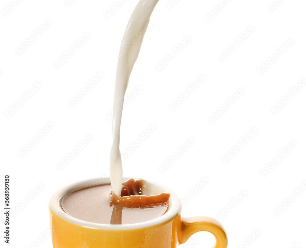 Pouring of milk in cup of hot coffee on white background