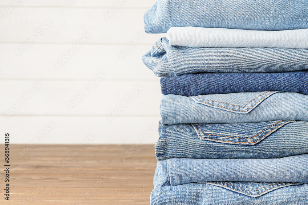 Stack of jeans pants on table