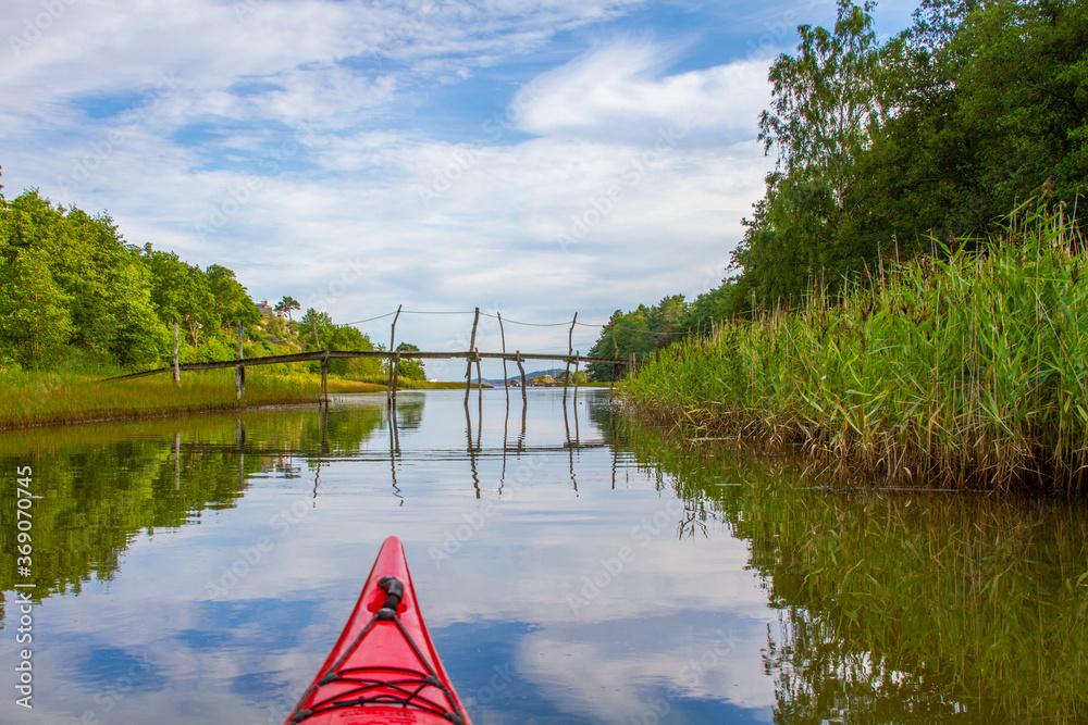 Kayaking on a narrow canal surrounded by reeds and vegetation. The water is calm and gives beautiful