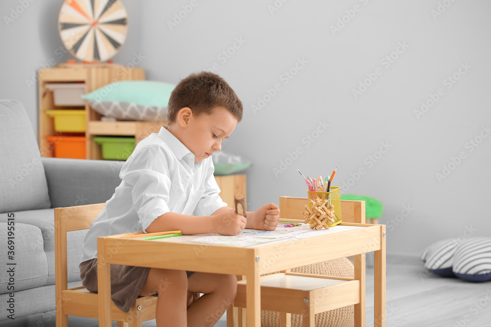 Cute little boy coloring pictures at home