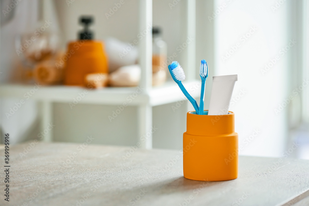 Tooth brush and paste on table in bathroom