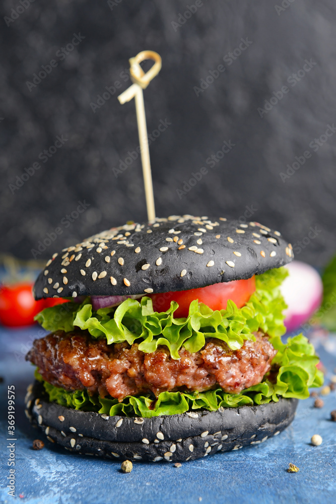 Tasty burger with black bun on table