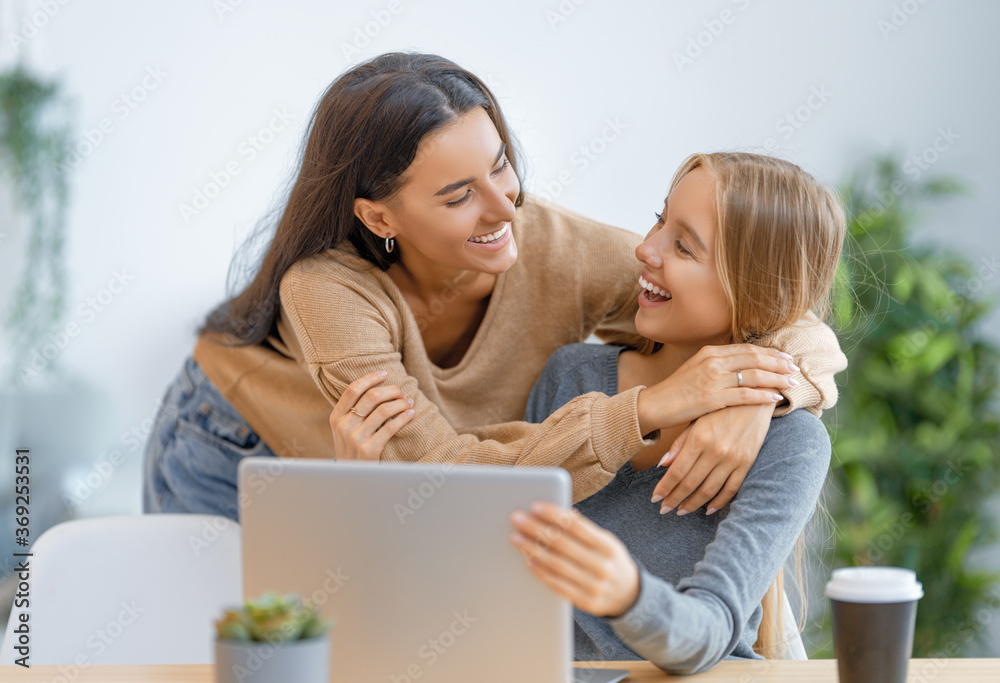 two happy young women using laptop