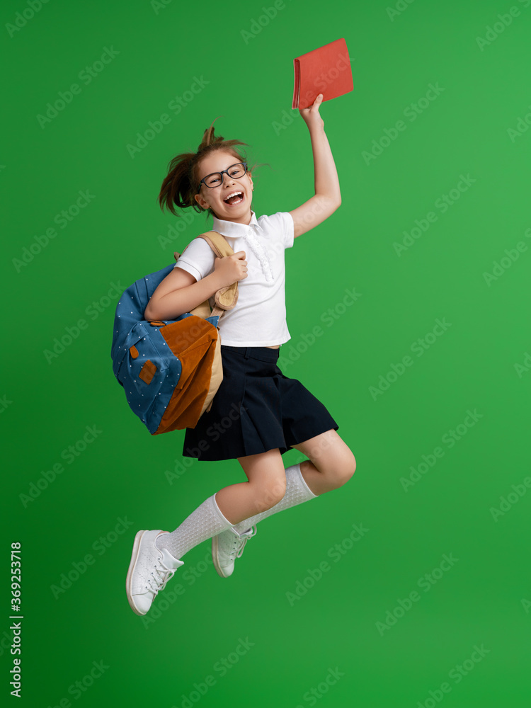 Kid with backpack on color background.