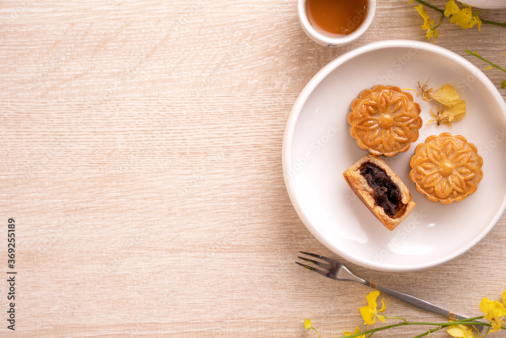 Mid-Autumn Festival holiday concept design of moon cake, mooncakes, tea set on bright wooden table w