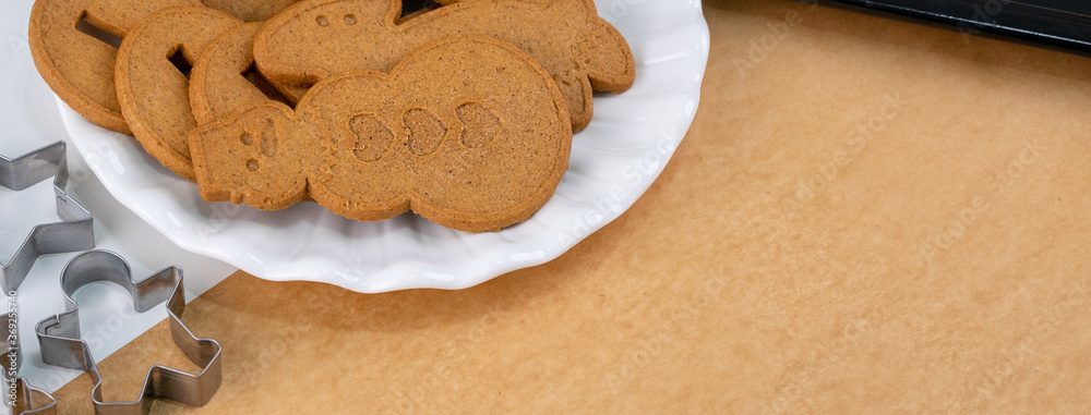 Young woman is decorating Christmas Gingerbread House cookies biscuit at home with frosting topping 