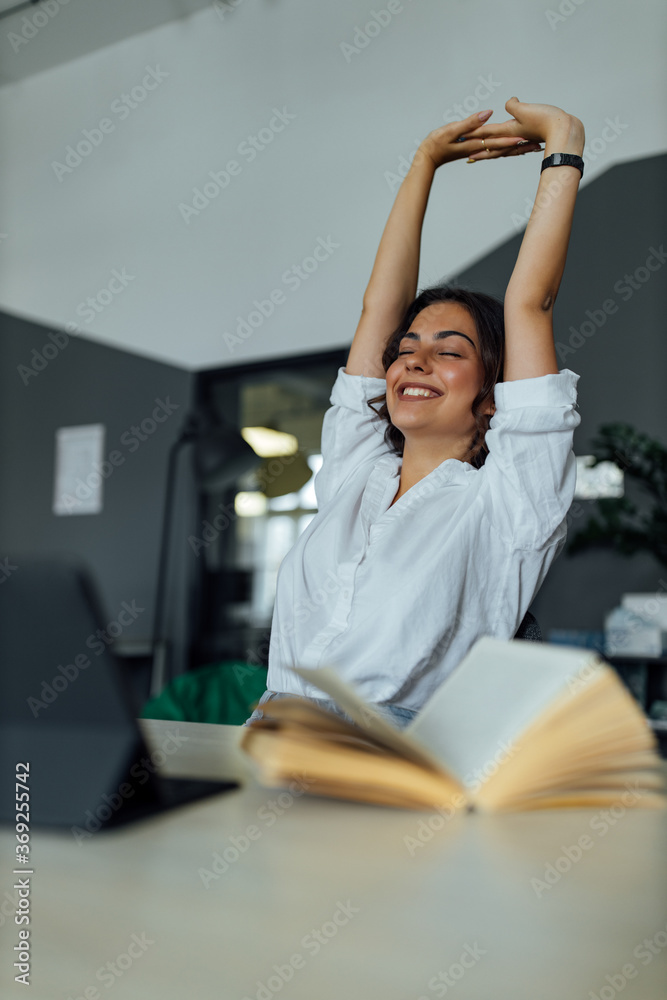 Happy young girl at work in office.