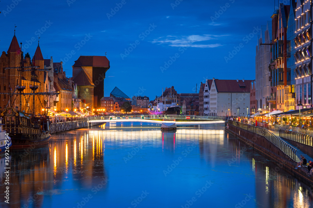 Amazing architecture of Gdansk old town at night with a new footbridge over the Motlawa River. Polan