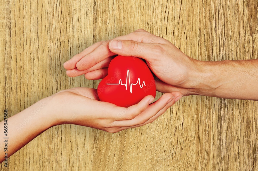 Man and woman hands holding the red heart