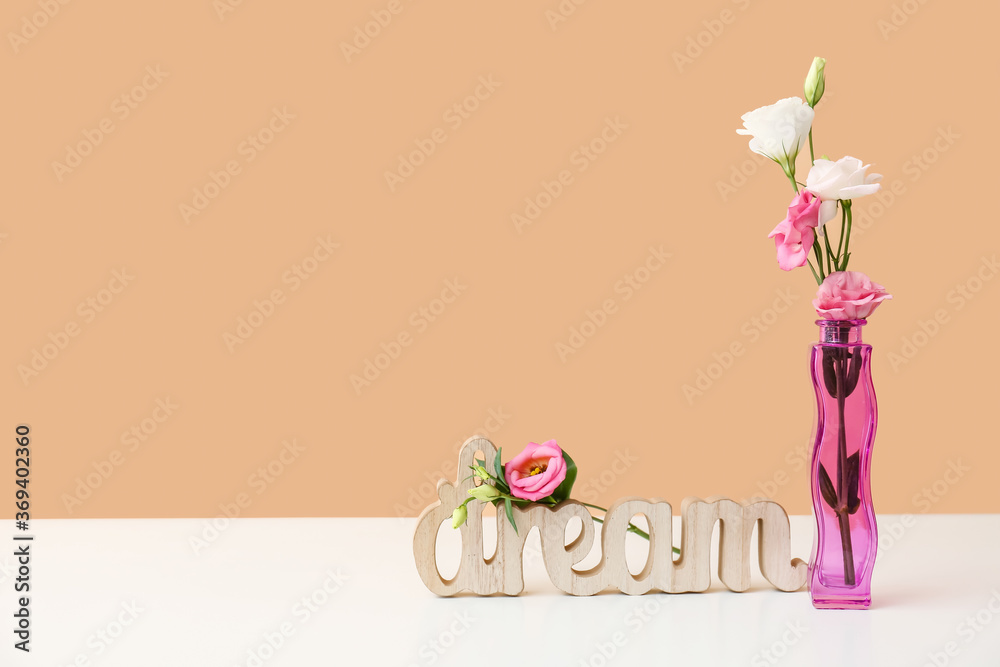 Beautiful vase with flowers on table against color background