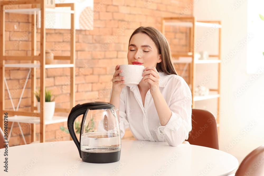 带着电热水壶的女人在家喝茶